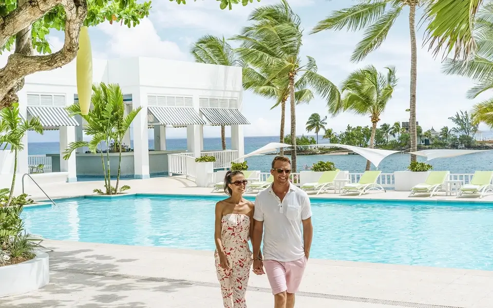 Couple taking a stroll around the pool