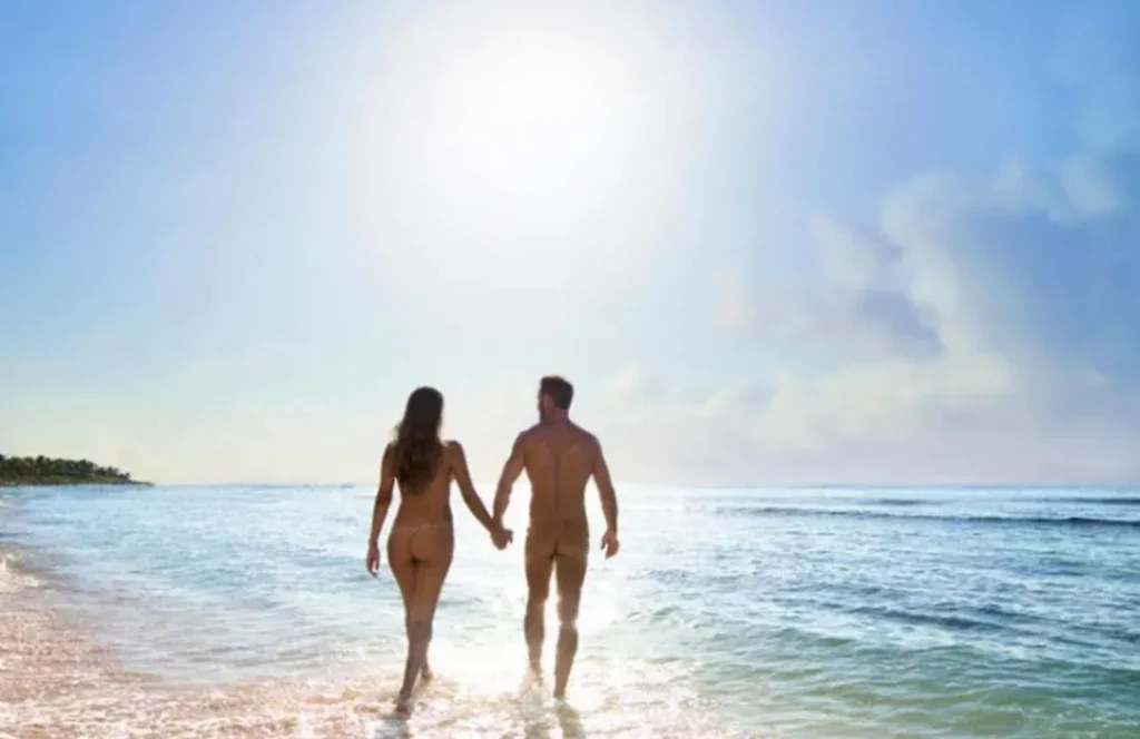 Nude couple walking on the beach